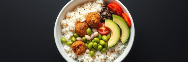 Healthy lunch bowl with rice, vegetables, and plant-based protein on a dark background photo