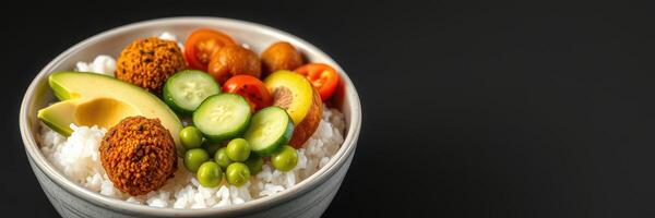 Colorful bowl of fresh vegetables and falafel served over rice in a minimalistic setting photo