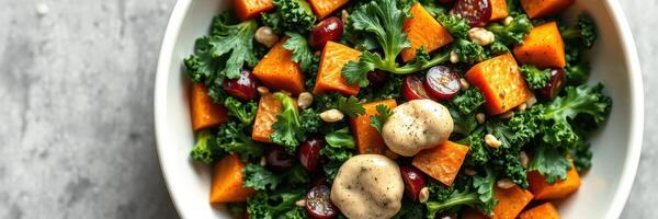 Colorful kale and sweet potato salad with nuts and dressing for a healthy meal photo