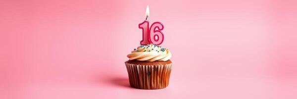 Sweet sixteen cupcake with candle and colorful sprinkles on a pink background photo