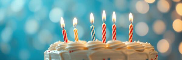 Celebration cake adorned with lit candles against a festive blue background during a special occasion photo