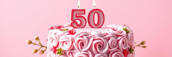 Celebration cake adorned with rose decorations and candles marking a 50th birthday in a festive atmosphere photo