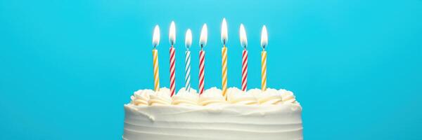 Birthday cake with lit candles celebrating a joyful gathering in a bright blue setting photo