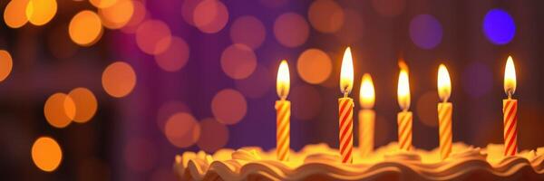 Celebration of a birthday with a beautifully decorated cake topped with candles glowing warmly in soft lighting photo