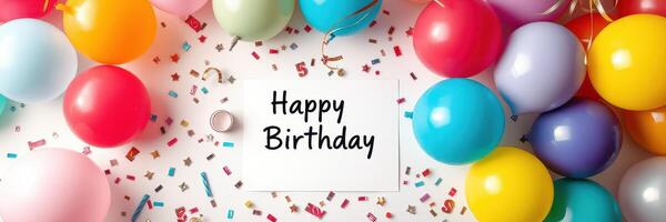 Colorful birthday celebration with balloons and confetti arranged around a greeting card in a festive setting photo