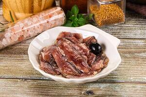 Canned anchovy with oil in the bowl photo