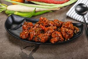 Manchurian chicken with sauce and spices photo