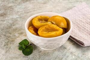 Canned marinated peach in syrop photo
