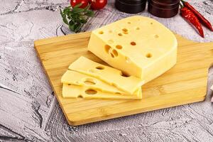 Maasdam cheese piece with slices photo