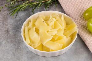 Parmesan cheese slices in the bowl photo