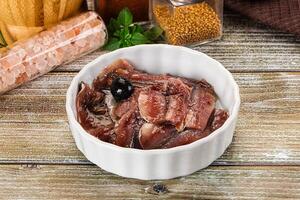Canned anchovy with oil in the bowl photo