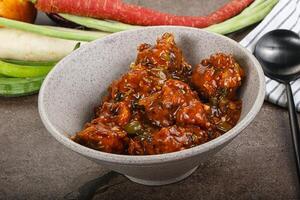 Manchurian chicken with sauce and spices photo