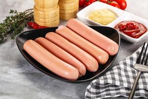 Boiled sausages with ketchup and mustard photo