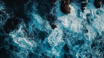 The image is of a large body of water with white foam and rocks photo