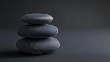 Three large black rocks are stacked on top of each other photo