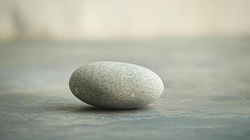 A large rock sits on a grey surface photo