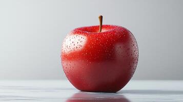 A red apple with a stem is sitting on a table photo