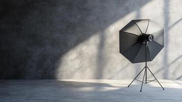 A black umbrella is sitting on a tripod in a room with a grey wall photo