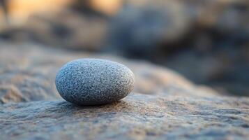 A small gray rock sits on a rocky surface photo