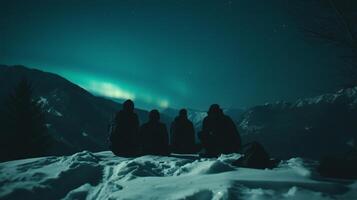 A group of people watch the northern lights at night against the backdrop photo