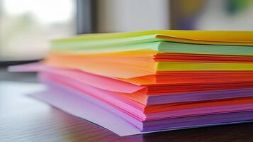 Printed paper sheets are neatly stacked on a wooden table photo