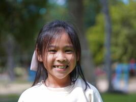 Portrait of a smiling little girl in a park on a sunny day. photo