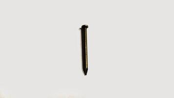 Close up of a single, dark colored nail isolated on a white background. Simple, minimalist image ideal for construction, DIY, or hardware concepts. photo