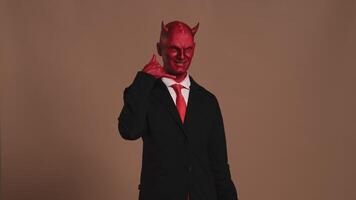 Red devil businessman making a call me gesture video