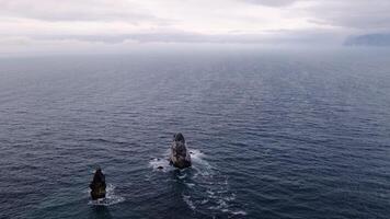 view from above of two cliffs in the sea, dusky weather, autumn or winter video