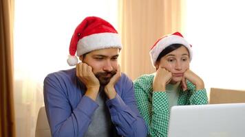 man and woman in Santa hats are smiling and hugging video