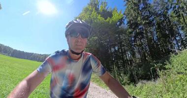 Cyclist riding through a forest trail, transitioning from rider focus to forward motion perspective video