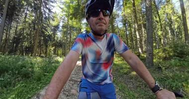 Cyclist riding through a forest trail, transitioning from rider focus to forward motion perspective video