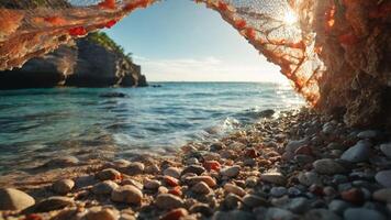 A serene beach view framed by a natural arch, showcasing pebbles and calm waters. photo