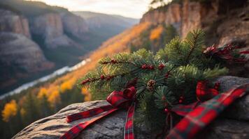 A festive arrangement of pine and berries on a rock, overlooking a scenic autumn landscape. photo