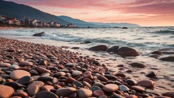 A serene beach at sunset with smooth pebbles and gentle waves lapping the shore. photo