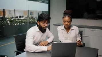 Multiethnic business team diverse people brainstorm in office two arabian men and african woman using laptop computer discussing startup coworkers group discuss corporate project software teamwork photo