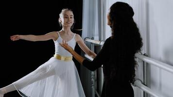 Caucasian girl teenager student ballerina in tutu doing dancing exercises near ballet barre listening to explanations advice from adult teacher female trainer rehearsing choreography dance education photo