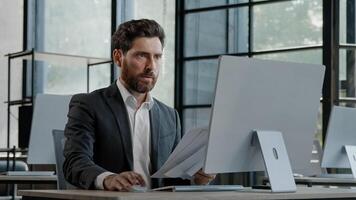 Unmotivated tired exhausted burnout adult worker manager businessman sitting in office with paperwork difficult task incorrect data in papers and computer error throws documents holding head with sad photo