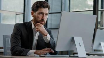 Focused Caucasian bearded adult 40s man CEO company worker manager boss businessman working on computer in office searching solution of problem decide difficult task creating online project thinking photo