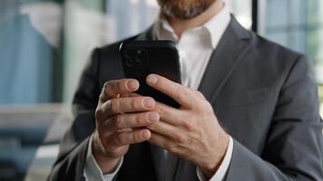 Closeup male hands unrecognizable unknown Caucasian man professional worker businessman holding cellphone mobile phone texting typing chatting in social networks receive message web surfing online app photo