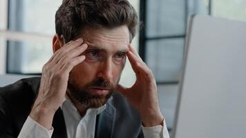 Ill tired frustrated Caucasian bearded 40s business man worker upset sad manager feel stressed look at computer screen suffer from lost job bad news worried of problem failed startup trouble in office photo