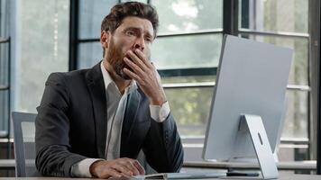 Portrait tired lazy napping yawn adult bearded man male manager worker bored at work project online in computer in office Caucasian mature ill businessman need energy asleep feel overworked exhaustion photo