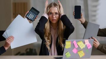 Sad overworked exhausted tired business girl with woman worker manager in glasses holding head multitasking stress problems with work sitting table with laptop around calculator notebook papers phone photo