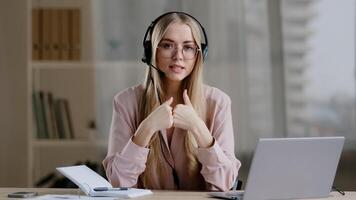 Woman helpline manager consultant adviser instructor distant teacher coach in headphones speaks showing gestures in air explaining online briefing guide call conference help remotely e-learning photo