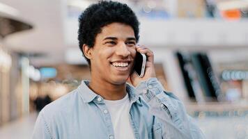 Close-up african guy looking at mobile phone answering unexpected call talking to girlfriend family smiling laughing chatting on cellphone remote friendly talk cellular connection using smartphone app photo