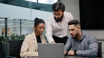 Arab man coach corporate trainer boss leader teacher mentor teaching interns managers employees use online application software shows in laptop discussing company education studying project in office photo