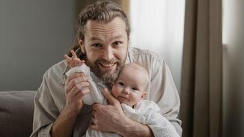 Webcam view portrait caucasian bearded dad and infant newborn small girl little kid daughter son waving hands greeting talking to camera call at home. Closeup father with little child conference photo