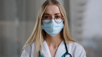 Female doctor in medical mask looking at camera talking angry show index finger no negative gesture mad stressed woman psychologist nurse in white coat office show one with hand aggressive explain photo