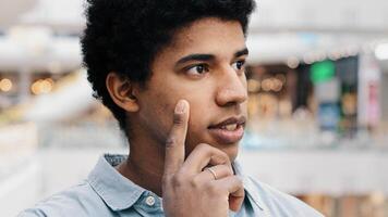 Close-up male pensive face, portrait african american puzzled business man standing indoors deep in thoughts thinking recollecting memory creating plan happy raises index finger comes up with idea photo