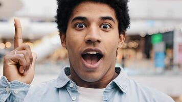 Close-up male pensive face, portrait african american puzzled business man standing indoors deep in thoughts thinking recollecting memory creating plan happy raises index finger comes up with idea photo